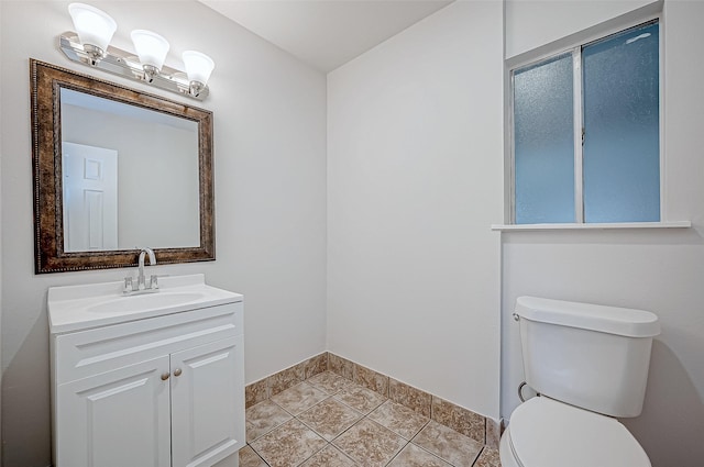 bathroom with toilet, vanity, and tile patterned floors