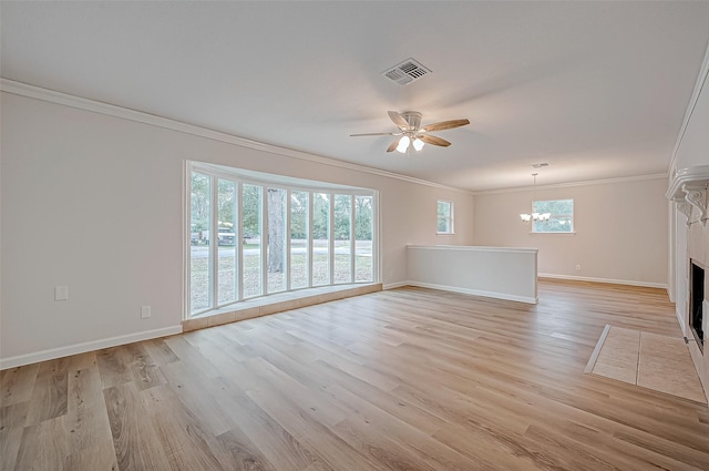 unfurnished living room featuring ceiling fan with notable chandelier, a healthy amount of sunlight, ornamental molding, and light hardwood / wood-style floors