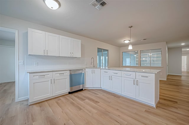 kitchen featuring kitchen peninsula, white cabinetry, decorative light fixtures, stainless steel dishwasher, and tasteful backsplash