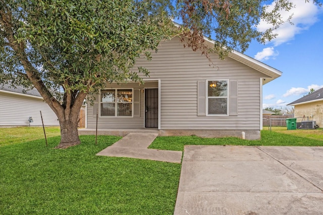 view of front facade featuring central AC, a front yard, and a patio