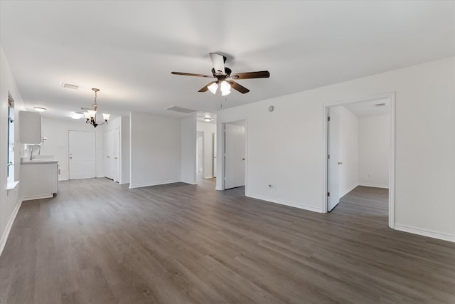 unfurnished living room featuring sink, dark wood-type flooring, and ceiling fan with notable chandelier