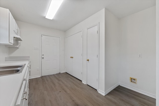 kitchen with sink, white cabinetry, and light wood-type flooring