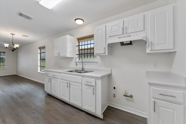 kitchen with sink, white cabinetry, decorative light fixtures, and a wealth of natural light