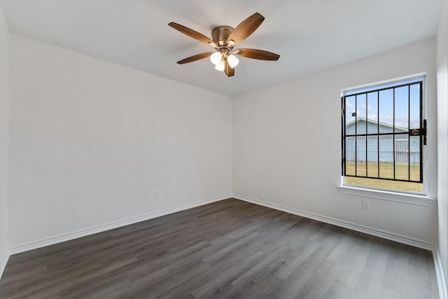 empty room featuring ceiling fan, dark hardwood / wood-style flooring, and a water view