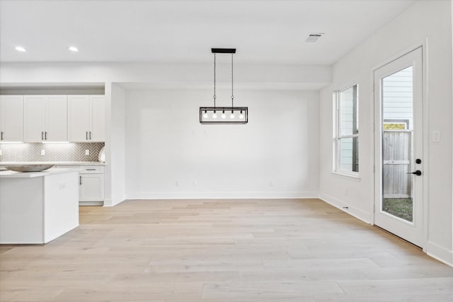 unfurnished dining area featuring light wood-type flooring