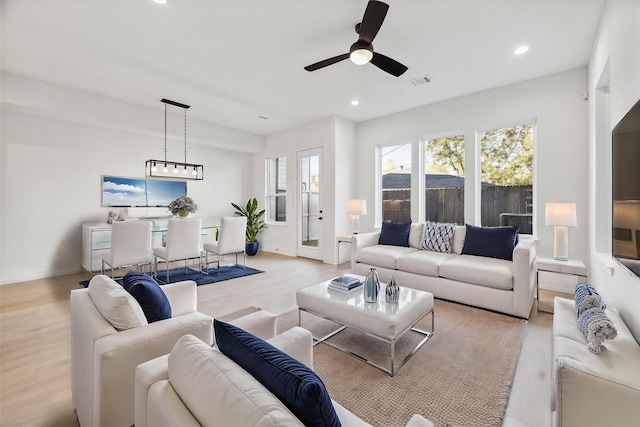 living room featuring ceiling fan and light hardwood / wood-style flooring