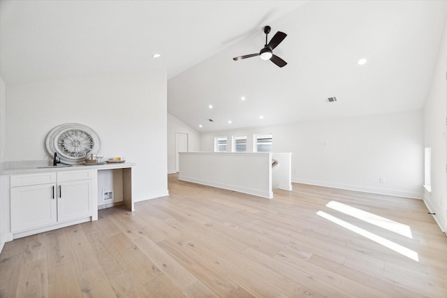 unfurnished living room with lofted ceiling, light wood-type flooring, ceiling fan, and sink