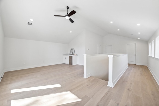 additional living space with ceiling fan, light wood-type flooring, and vaulted ceiling