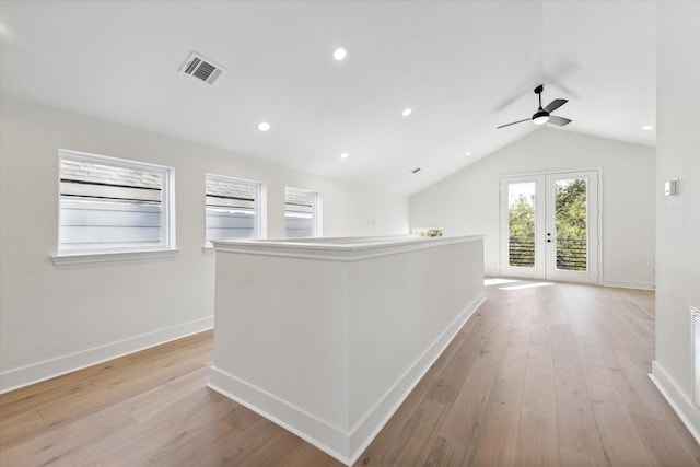 hall featuring light hardwood / wood-style floors, french doors, and lofted ceiling