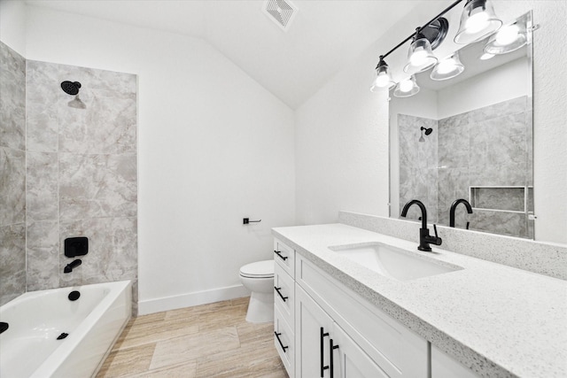 full bathroom featuring tiled shower / bath combo, lofted ceiling, vanity, and toilet