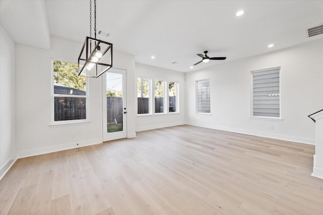 unfurnished living room with light hardwood / wood-style floors and ceiling fan with notable chandelier