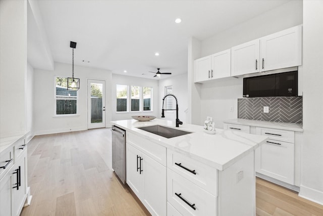 kitchen featuring sink, white cabinets, and a center island with sink