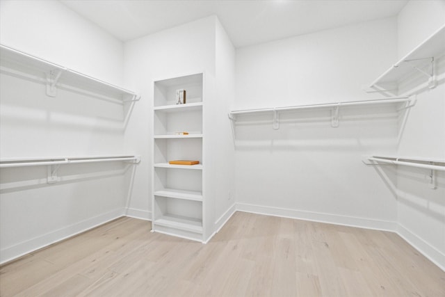 spacious closet with light hardwood / wood-style flooring