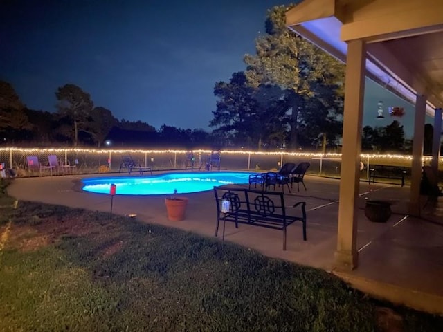 pool at twilight featuring a patio, fence, and a fenced in pool