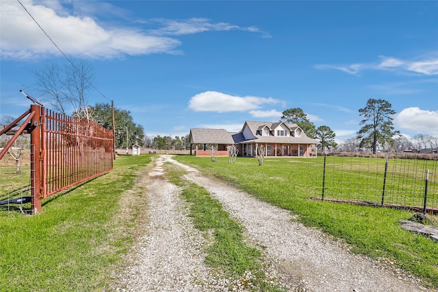 view of road with a rural view, driveway, and a gated entry