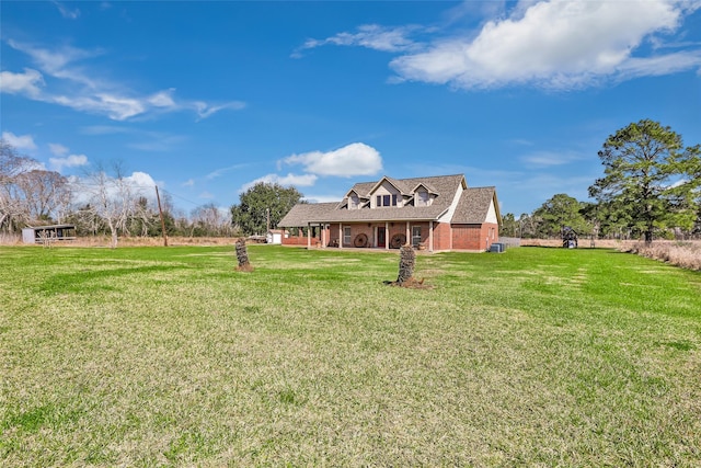 rear view of house with brick siding and a lawn