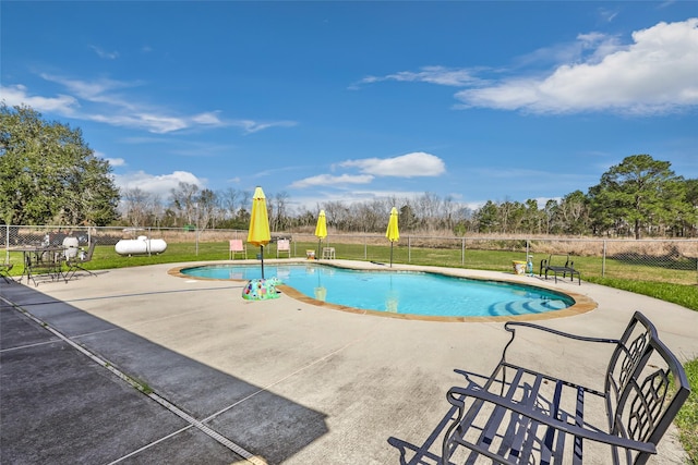 view of pool featuring a fenced in pool, fence, a lawn, and a patio