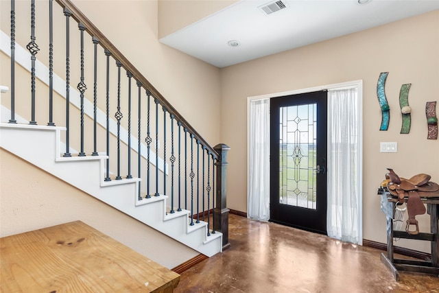 entryway featuring finished concrete flooring, stairs, visible vents, and baseboards