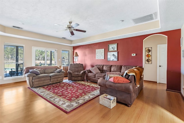 living room with visible vents, a textured ceiling, and wood finished floors