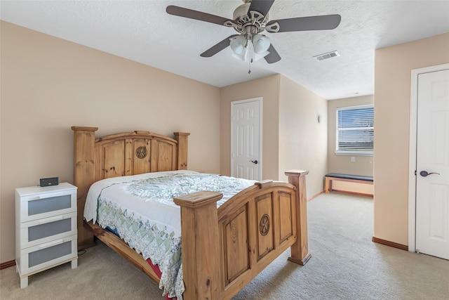 bedroom with visible vents, light carpet, ceiling fan, a textured ceiling, and baseboards