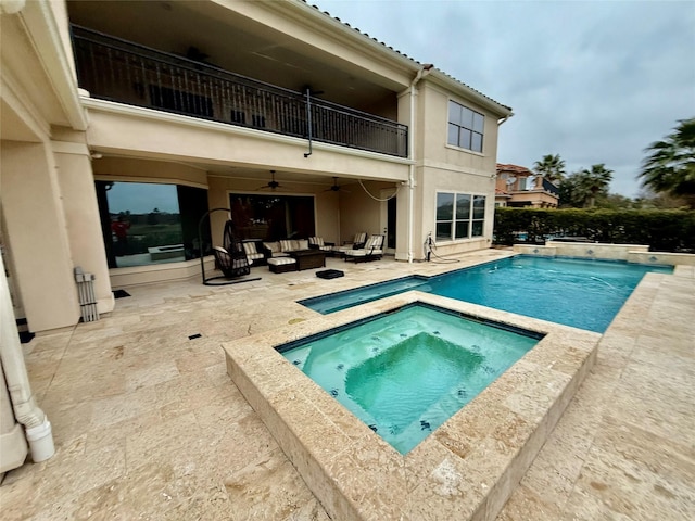 rear view of property featuring a balcony, a swimming pool with hot tub, ceiling fan, outdoor lounge area, and a patio area