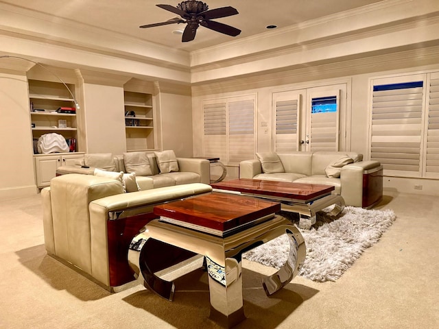 carpeted cinema with built in features, ceiling fan, crown molding, and a tray ceiling