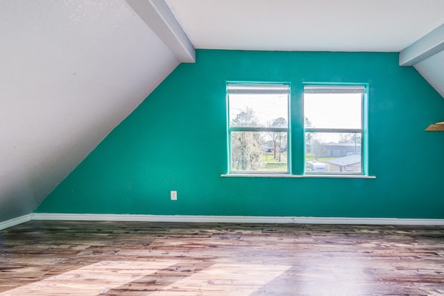 additional living space featuring lofted ceiling with beams and hardwood / wood-style flooring