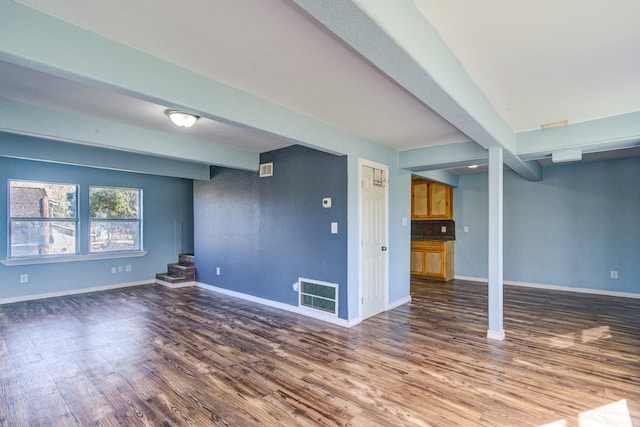 unfurnished living room with beamed ceiling and hardwood / wood-style flooring