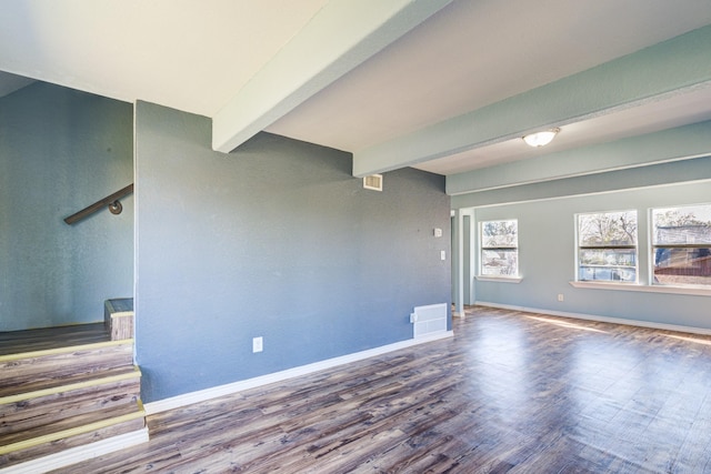 empty room with wood-type flooring and beamed ceiling