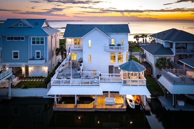 back house at dusk featuring a water view