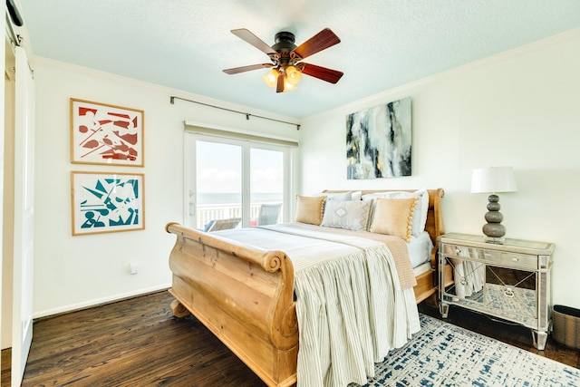 bedroom featuring dark wood-type flooring, a textured ceiling, ceiling fan, and ornamental molding