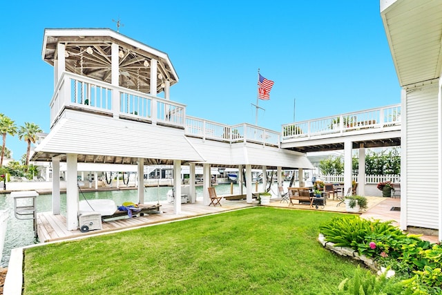 rear view of property featuring a patio, a lawn, and a water view