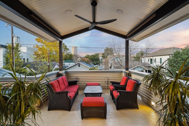 patio terrace at dusk with an outdoor living space, a balcony, and ceiling fan