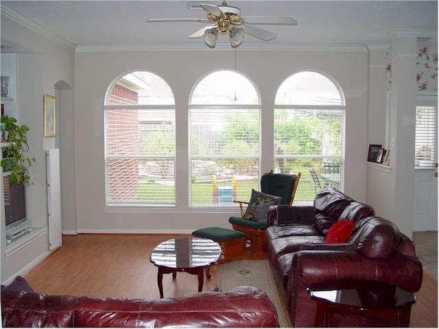 living room with ceiling fan, crown molding, and hardwood / wood-style flooring