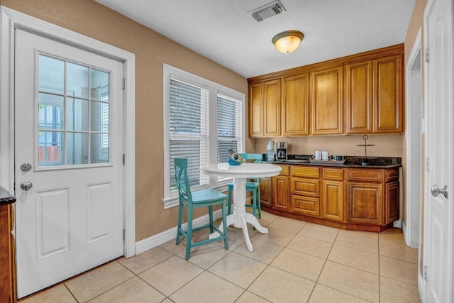 kitchen with dark stone counters and light tile patterned floors