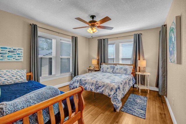 bedroom featuring hardwood / wood-style flooring, a textured ceiling, and ceiling fan