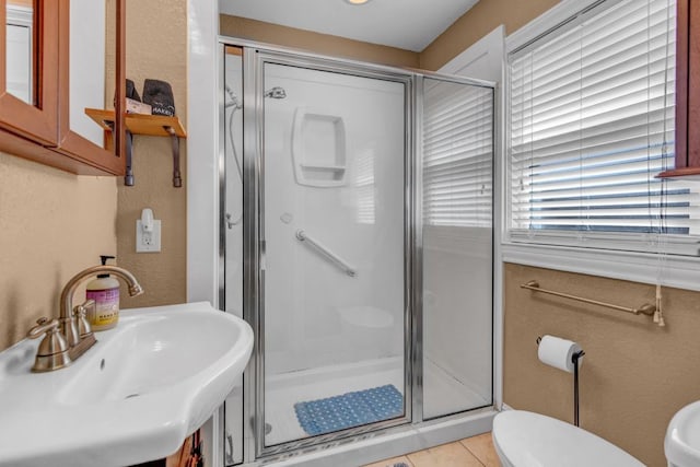 bathroom featuring sink, an enclosed shower, tile patterned floors, and a healthy amount of sunlight