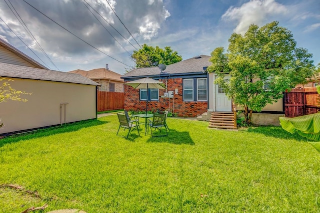 rear view of property with a lawn