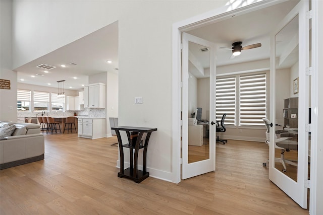 interior space featuring light wood-type flooring, french doors, and ceiling fan