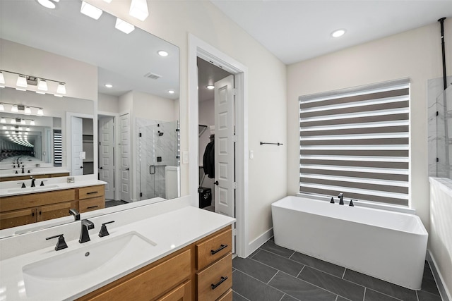 bathroom featuring tile patterned flooring, vanity, and plus walk in shower