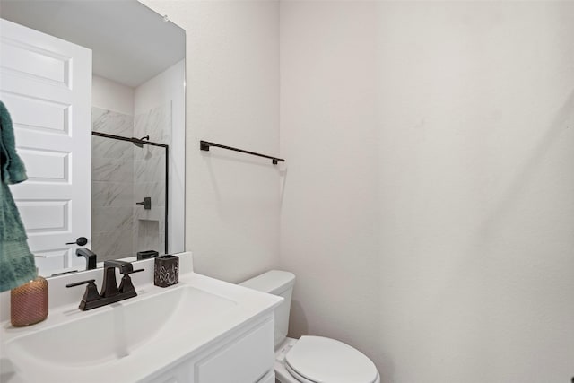 bathroom featuring toilet, vanity, and a tile shower