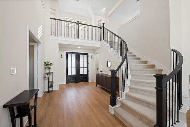 foyer entrance with french doors, a high ceiling, and hardwood / wood-style floors