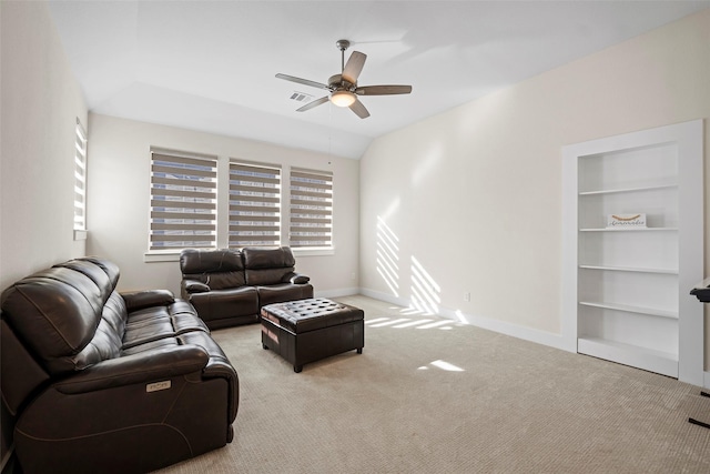 carpeted living room featuring ceiling fan, built in shelves, and vaulted ceiling