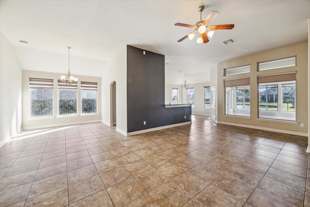 unfurnished living room with ceiling fan with notable chandelier and light tile patterned floors