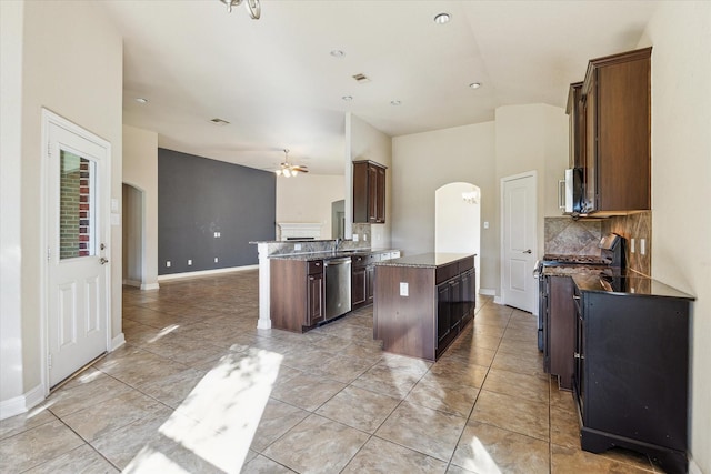 kitchen featuring a kitchen island, backsplash, appliances with stainless steel finishes, dark brown cabinets, and sink