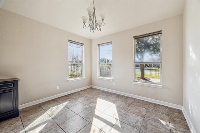 unfurnished dining area with light tile patterned floors and a chandelier