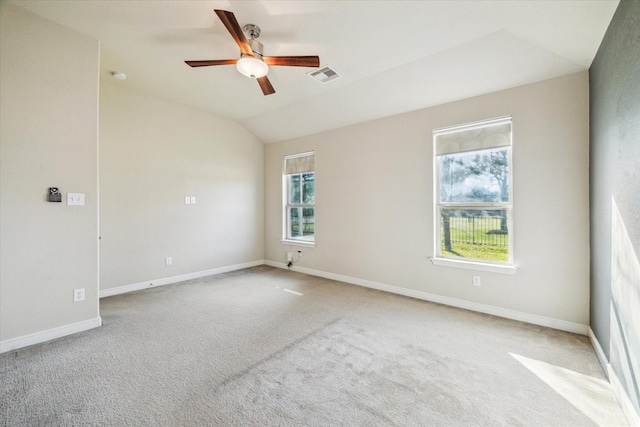 empty room featuring lofted ceiling, ceiling fan, and light colored carpet