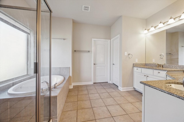 bathroom featuring tile patterned floors, tiled tub, and vanity