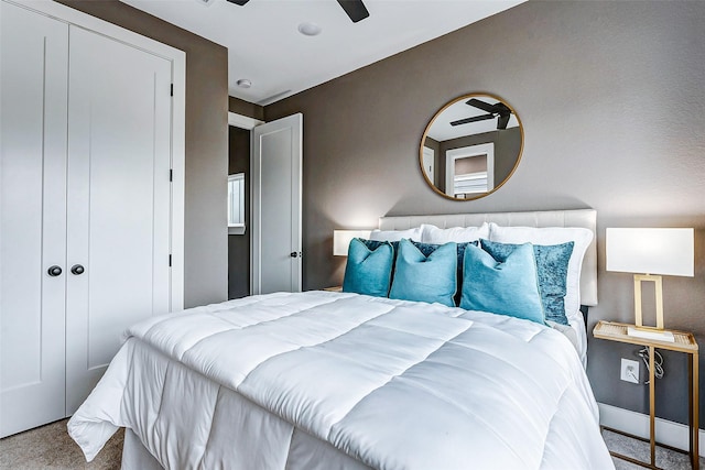 carpeted bedroom with ceiling fan and a closet