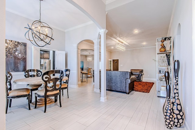 dining space with a chandelier, crown molding, and decorative columns